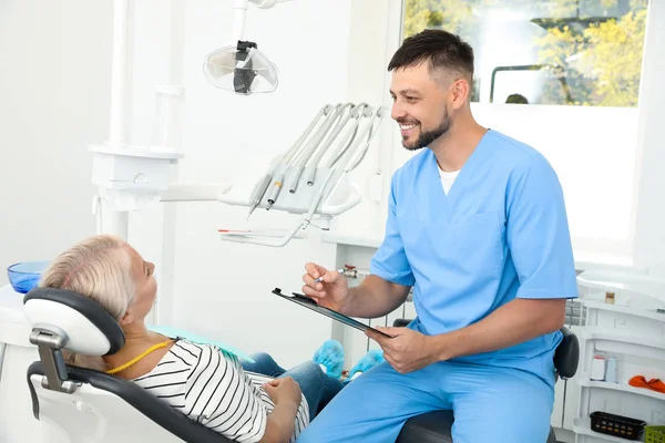 Odontólogo profesional que trabaja con paciente en clínica — Foto de Stock