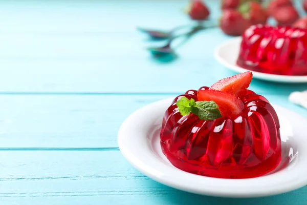 Läcker röd gelé med jordgubb och mynta på ljust blått träbord. Utrymme för text — Stockfoto