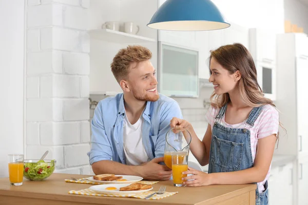 Boldog fiatal pár reggelizik az asztalnál a konyhában — Stock Fotó