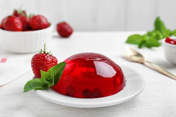 Délicieuse gelée rouge fraîche aux baies et menthe sur table en bois blanc — Photo