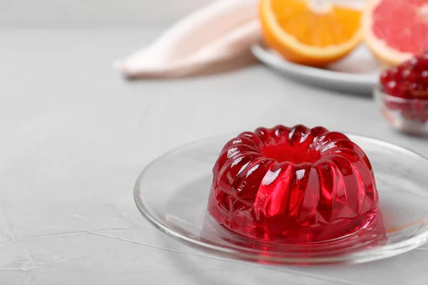 Вкусное свежее красное желе на сером столе, место для текста — стоковое фото
