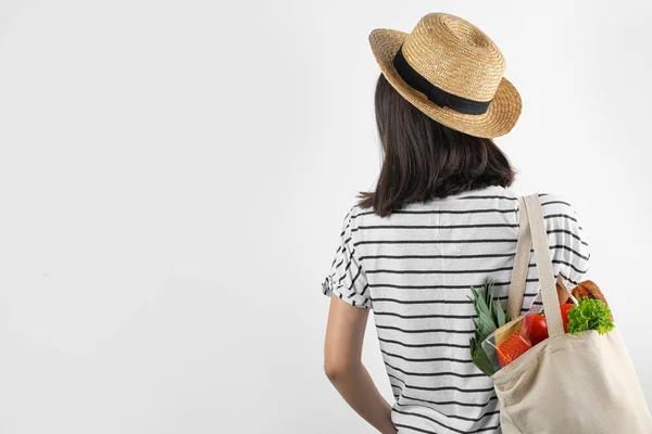 Žena držící nákupní tašku s čerstvou zeleninou na bílém pozadí — Stock fotografie