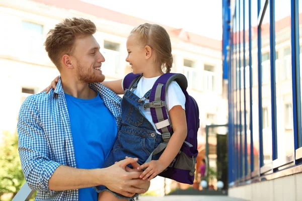 Joven padre sosteniendo a su pequeño hijo con la bolsa de la escuela al aire libre —  Fotos de Stock