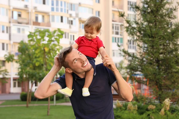 Otec s rozkošným malým dítětem venku. Šťastná rodina — Stock fotografie