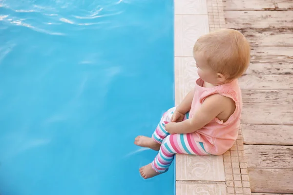 Małe dziecko siedzi w pobliżu odkrytego basenu. Niebezpieczna sytuacja — Zdjęcie stockowe