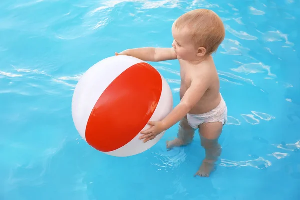 Kleine baby spelen met opblaasbare bal in het buitenzwembad. Gevaarlijke situatie — Stockfoto
