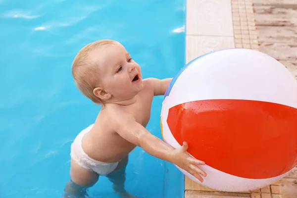 Piccolo bambino che gioca con la palla gonfiabile nella piscina all'aperto. Situazione pericolosa — Foto Stock