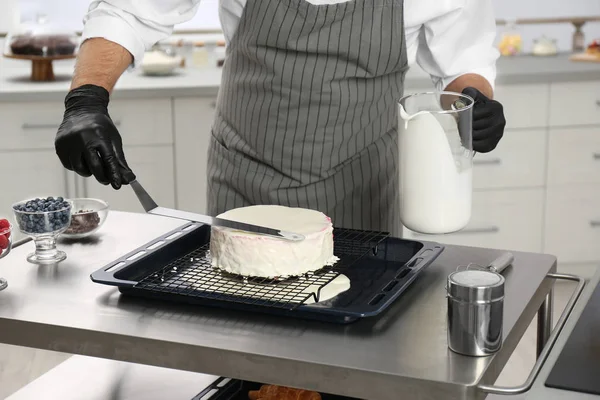 Мужчина кондитер готовит торт за столом на кухне, крупный план — стоковое фото