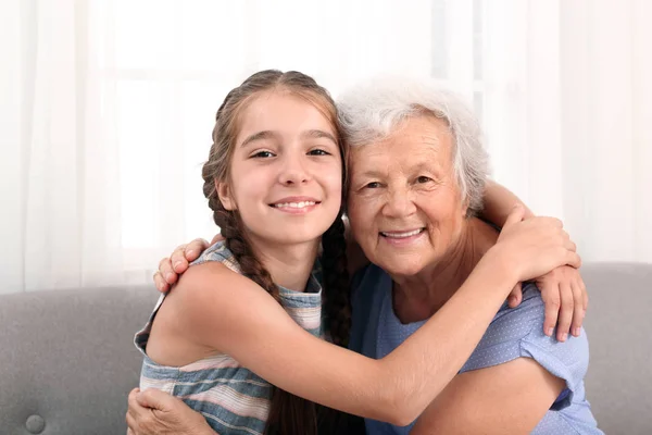 Ευτυχισμένο χαριτωμένο κορίτσι με τη γιαγιά της στο σπίτι — Φωτογραφία Αρχείου