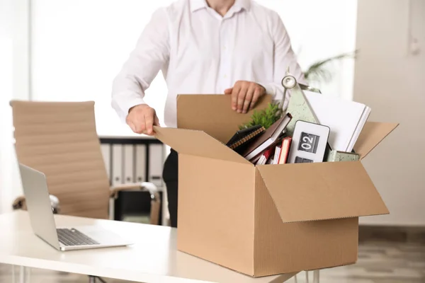Молодий чоловік з коробкою речей в офісі, крупним планом — стокове фото