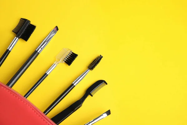 Set of professional eyebrow tools on yellow background. Space for text