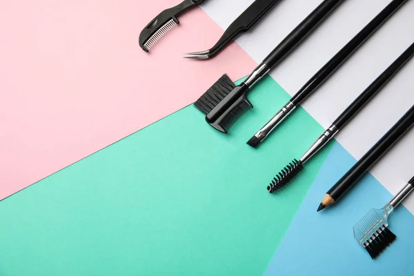 Set of professional eyebrow tools on color background, flat lay. Space for text