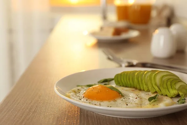 Leckeres Frühstück mit Spiegelei und Avocado auf Holztisch — Stockfoto