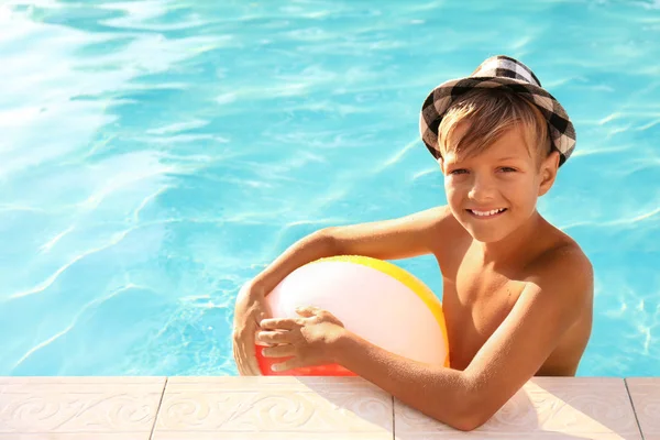Niño lindo feliz con bola inflable en la piscina — Foto de Stock