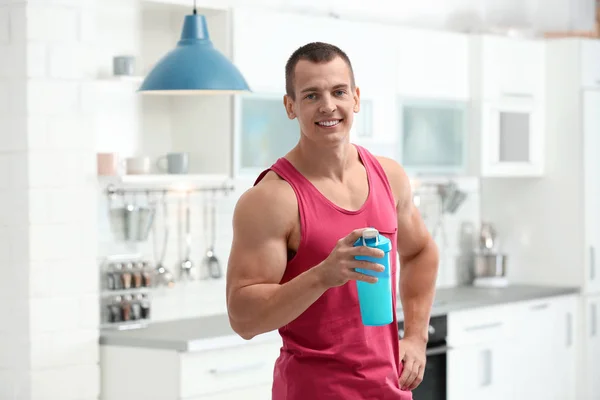 Atlético joven con batido de proteínas en la cocina — Foto de Stock