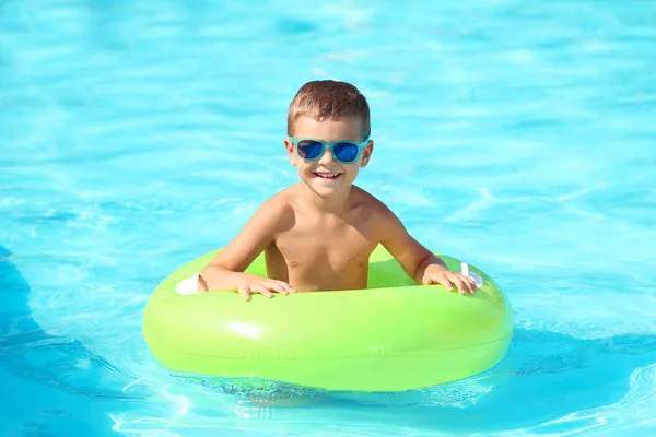 Menino feliz com anel inflável na piscina — Fotografia de Stock
