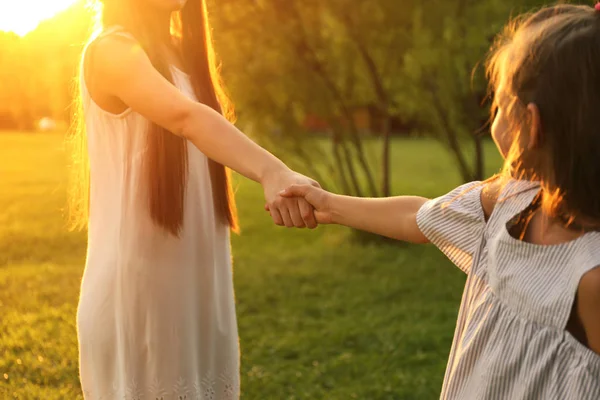 공원에서 그녀의 어머니와 손을 잡고 어린 소녀. 행복한 가족 — 스톡 사진