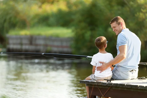Тато і син рибалять разом у сонячний день. Простір для тексту — стокове фото