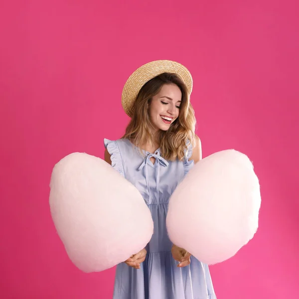 Gelukkige jonge vrouw met katoenen snoepjes op roze achtergrond — Stockfoto