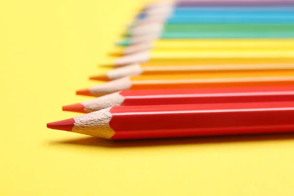 Diferentes lápis de cor no fundo amarelo, close-up — Fotografia de Stock