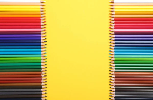 Lápices de color sobre fondo amarillo, plano. Espacio para texto — Foto de Stock
