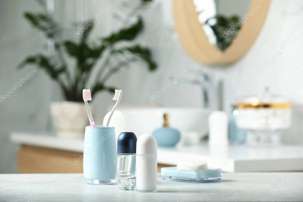 Roll-on deodorants with toiletry on table in bathroom, space for text