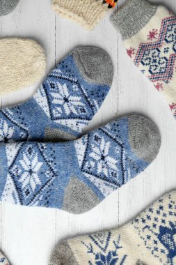 Beyaz ahşap arka plan üzerinde farklı örme çorap, düz yatıyordu