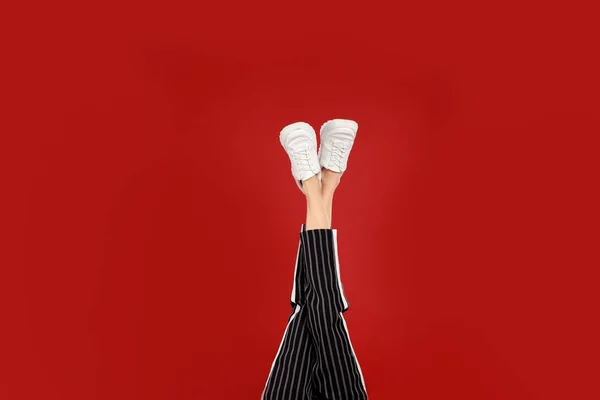 Mujer en zapatos deportivos con estilo sobre fondo rojo — Foto de Stock