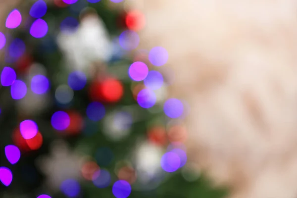 Mooie kerstboom met lichtjes tegen bruine achtergrond, wazig zicht. Ruimte voor tekst — Stockfoto