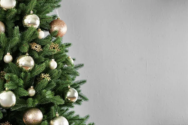 Mooie kerstboom met decor tegen lichtgrijze achtergrond. Ruimte voor tekst — Stockfoto