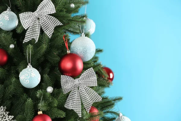 Schöner Weihnachtsbaum mit Dekor vor hellblauem Hintergrund. Raum für Text — Stockfoto