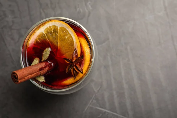 Glas mit Glühwein auf grauem Tisch, Draufsicht. Raum für Text — Stockfoto