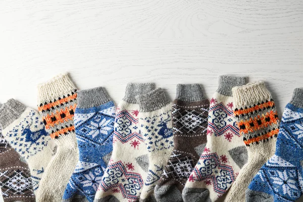 Weich gestrickte Socken auf weißem Holzhintergrund, flach liegend mit Platz für Text. Winterkleidung — Stockfoto