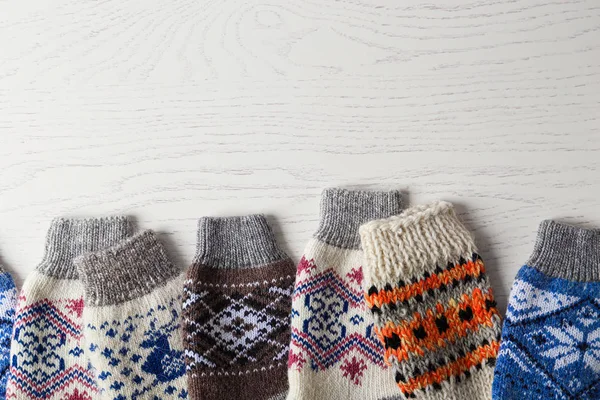 Weich gestrickte Socken auf weißem Holzhintergrund, flach liegend mit Platz für Text. Winterkleidung — Stockfoto