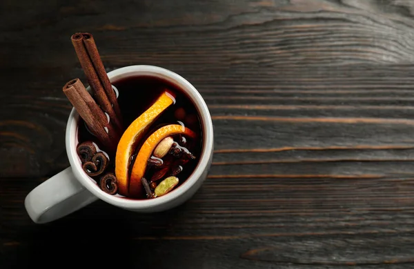 Tasse leckeren Glühwein auf schwarzem Holztisch, Draufsicht. Raum für Text — Stockfoto