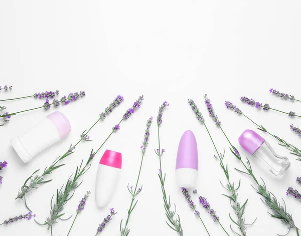 stock image Different deodorants and lavender flowers on white background, top view