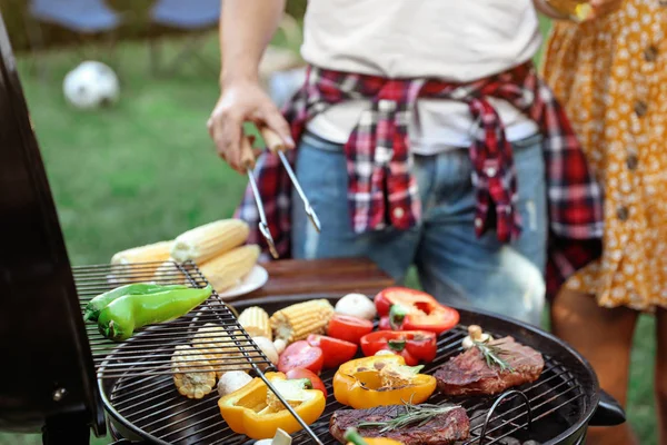 Homem cozinhar comida em churrasqueira ao ar livre, close-up — Fotografia de Stock