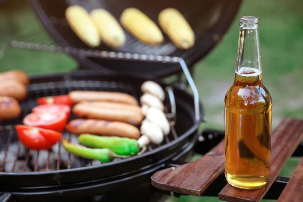 Bottiglia di birra sulla mensola del barbecue all'aperto — Foto Stock