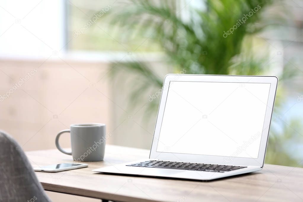 Modern laptop on desk in room. Home workplace