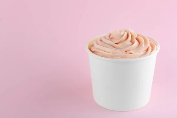 Copa con sabroso yogur helado sobre fondo rosa. Espacio para texto — Foto de Stock