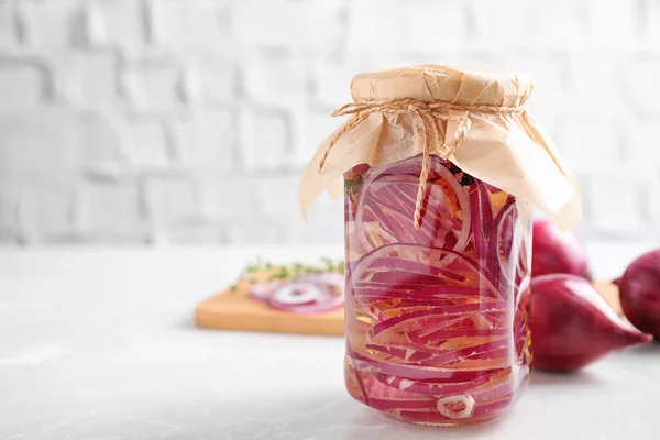 Jar of pickled onions on white table. Space for text — Stock Photo, Image