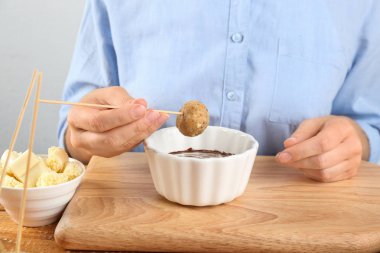 Ahşap tahta üzerinde pasta pop ve çikolata frosting ile genç kadın, closeup