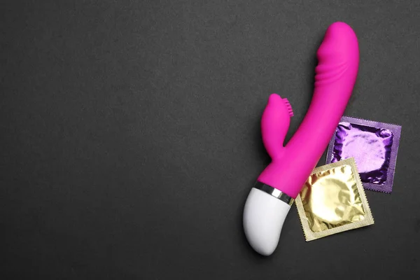 Wibrator i prezerwatywy na czarnym tle, widok z góry z miejscem na tekst. Sex gry — Zdjęcie stockowe