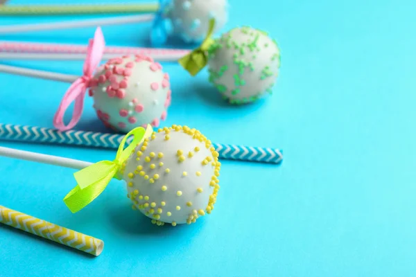Tasty cake pops and straws on light blue background. Space for text — Stock Photo, Image