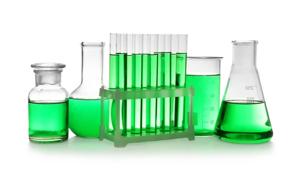 Laborgläser mit grüner Flüssigkeit auf weißem Hintergrund — Stockfoto