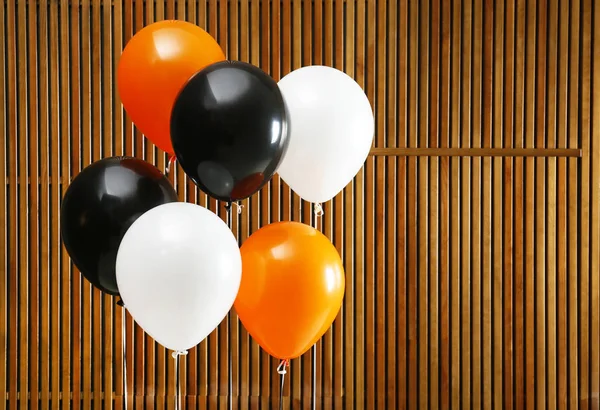 Colorful balloons against wooden wall, space for text. Halloween party — Stock Photo, Image