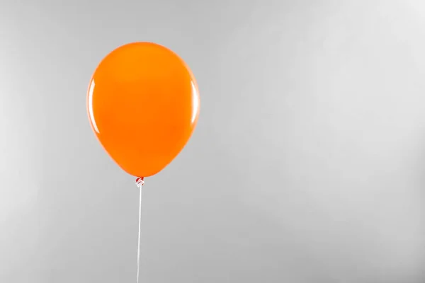 Balão laranja para festa de Halloween em fundo cinza claro, espaço para texto — Fotografia de Stock