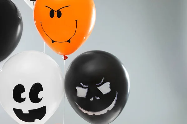 Ballons fantomatiques pour la fête d'Halloween sur fond gris clair, espace pour le texte — Photo