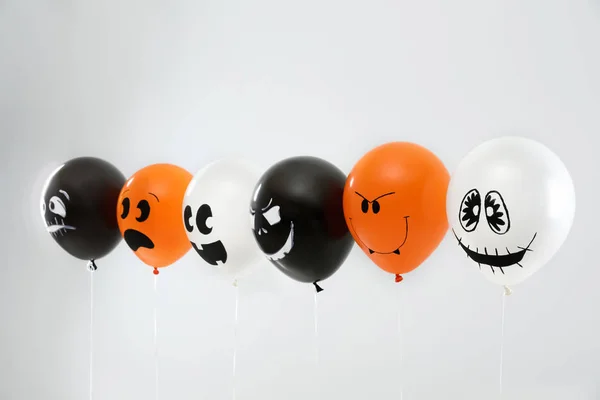 Gruselige Luftballons für die Halloween-Party auf hellgrauem Hintergrund — Stockfoto