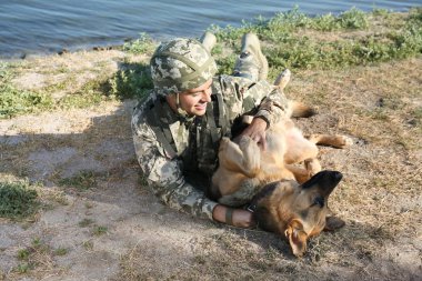 Alman çoban köpeği Nehri yakınında ile askeri üniformalı erkeklere